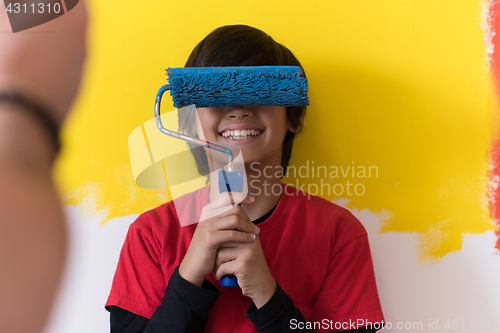 Image of young boy painter with paint roller