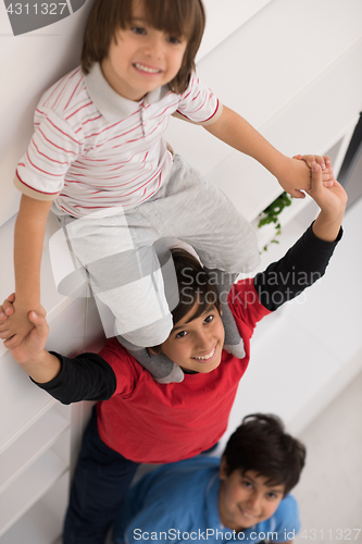 Image of young boys posing line up piggyback top view