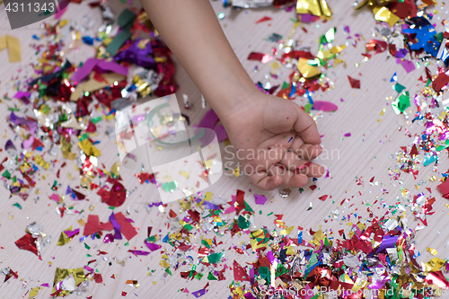 Image of Children\'s hand with confetti in background