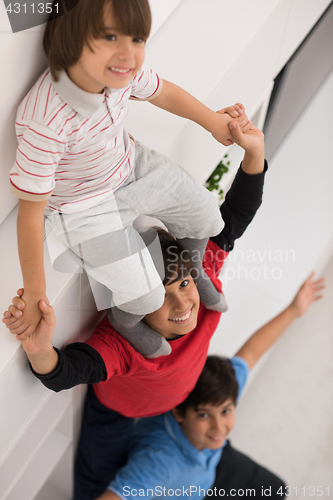 Image of young boys posing line up piggyback top view