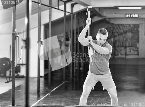 Image of man workout with hammer and tractor tire