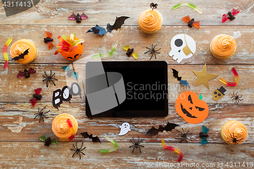 Image of tablet pc, halloween party decorations and treats