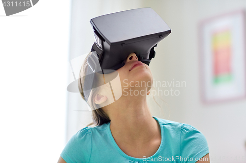 Image of happy girl in vr headset or 3d glasses at home
