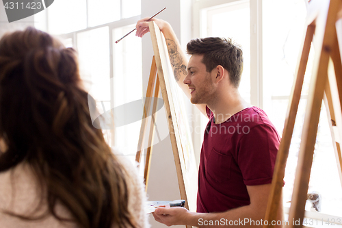 Image of artists with easels painting at art school