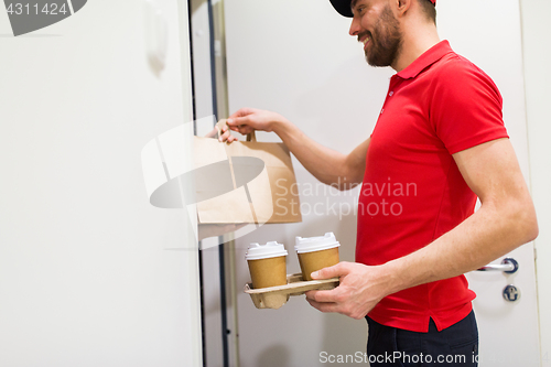 Image of delivery man with coffee and food at customer home