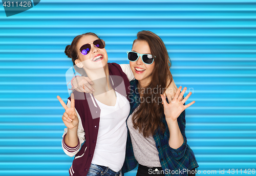 Image of smiling teenage girls in sunglasses showing peace