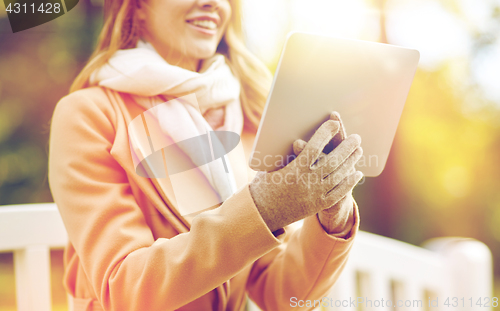 Image of close up of woman with tablet pc in autumn park