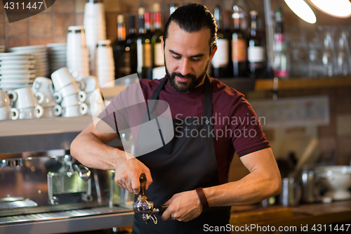 Image of barista man making espresso at bar or coffee shop