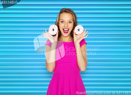 Image of happy woman or teen girl with donuts