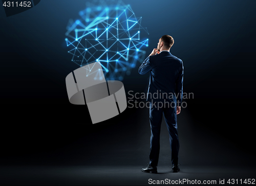 Image of businessman in suit from back over black