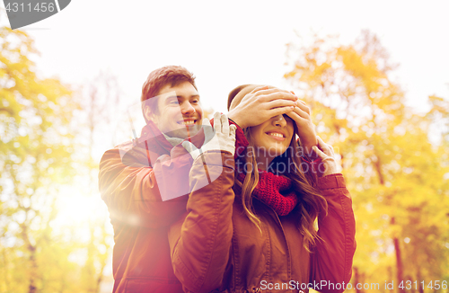 Image of happy young couple having fun in autumn park