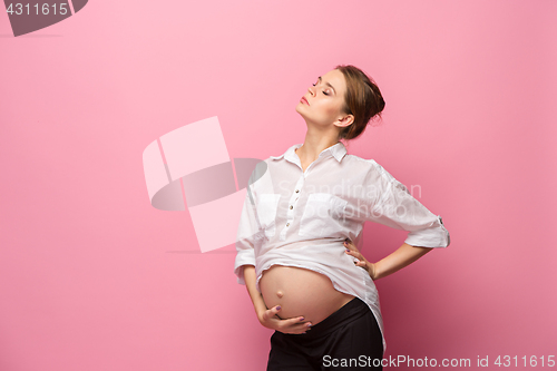 Image of Young beautiful pregnant woman standing on pink background