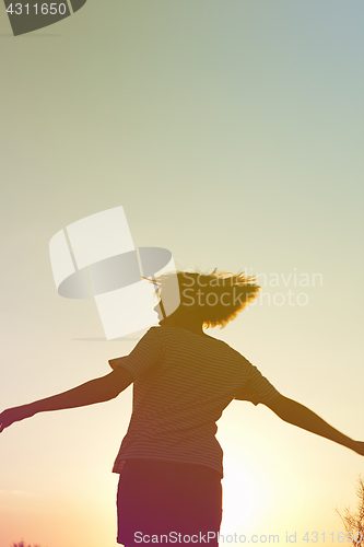 Image of Silhouette of a dancing woman at sunset.