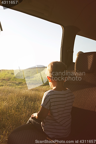 Image of Child in the car and looks into the distance.