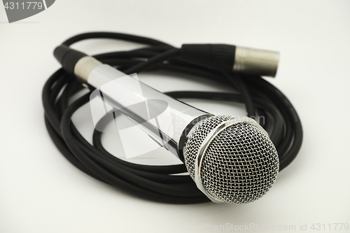 Image of vintage microphone with wire on white