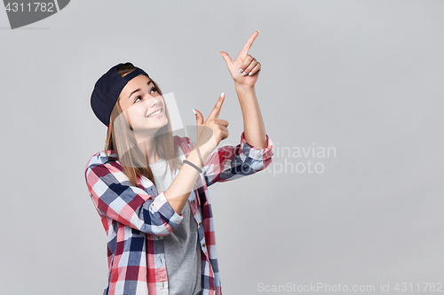 Image of Teen girl pointing up at empty copy space