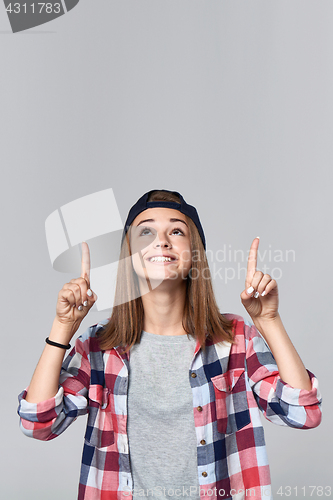 Image of Teen girl pointing up at empty copy space