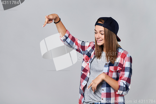 Image of Teen girl pointing down at empty copy space