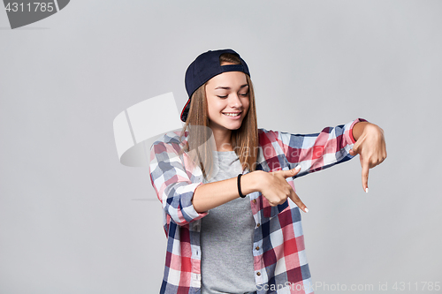 Image of Teen girl pointing down at empty copy space