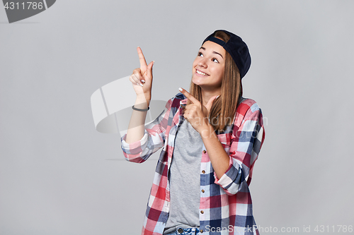 Image of Teen girl pointing up at empty copy space