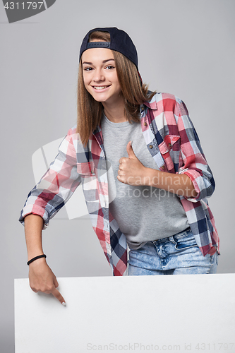 Image of Teen girl pointing up at empty copy space