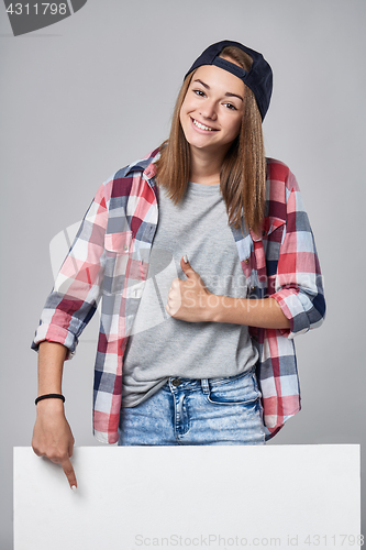 Image of Teen girl pointing up at empty copy space