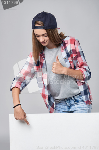 Image of Teen girl pointing up at empty copy space
