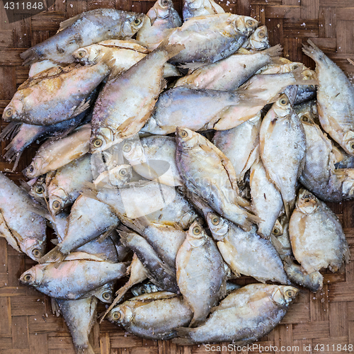 Image of Mackerel fishes in round bamboo basket for sale in local market.