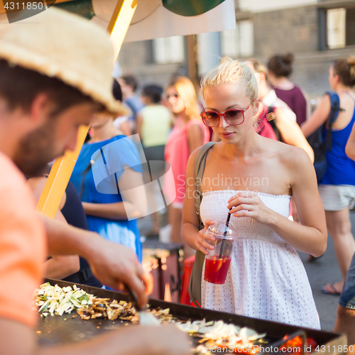 Image of Woman buying meal at street food festival.