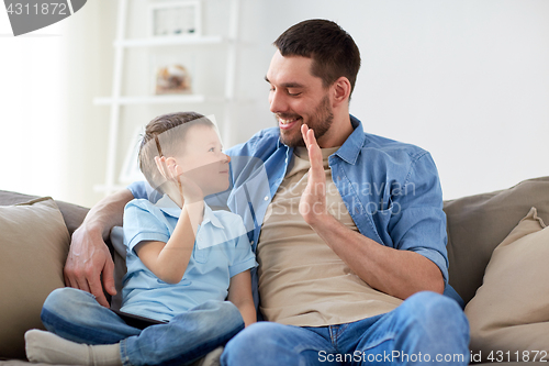 Image of father and son doing high five at home