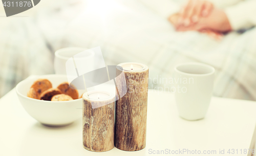 Image of close up of candles, cookies and tea cups on table