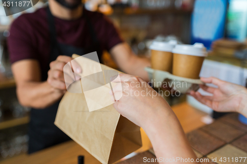 Image of man or bartender serving customer at coffee shop