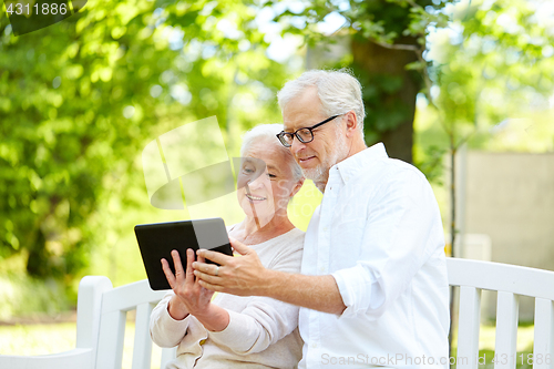 Image of happy senior couple with tablet pc in city park