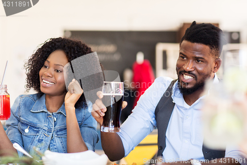 Image of happy african american couple with drinks at bar