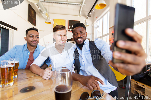 Image of friends taking selfie and drinking beer at bar