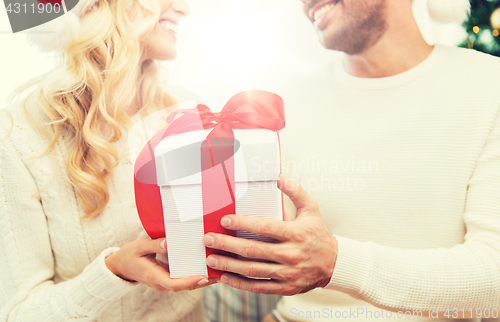 Image of close up of couple with christmas gift at home