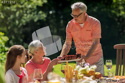 Image of happy family having dinner or summer garden party