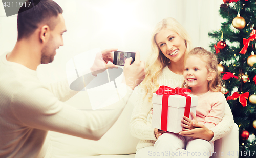 Image of family taking picture with smartphone at christmas