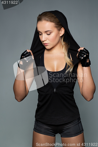 Image of young woman in black sportswear posing