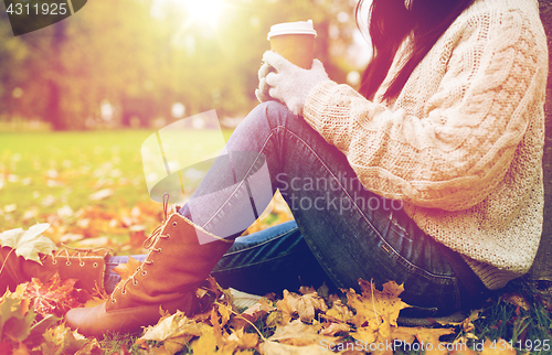 Image of close up of  woman drinking coffee in autumn park