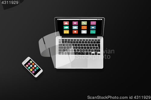 Image of laptop computer with menu icons and smartphone