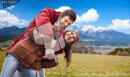 Image of happy young couple having fun over alps mountains