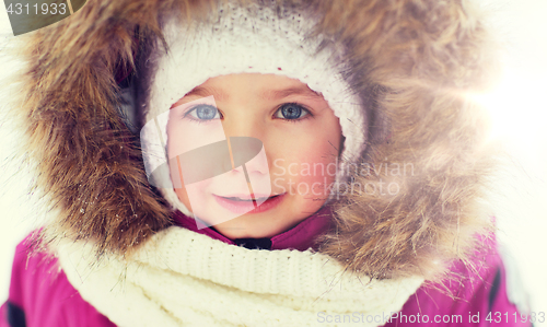 Image of face of happy little kid or girl in winter clothes