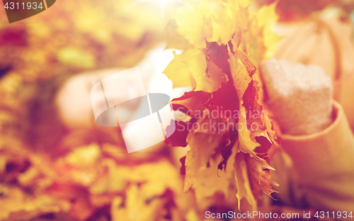 Image of close up of happy woman lying on autumn leaves