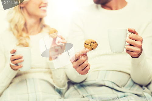 Image of close up of happy couple with cookies and tea cups