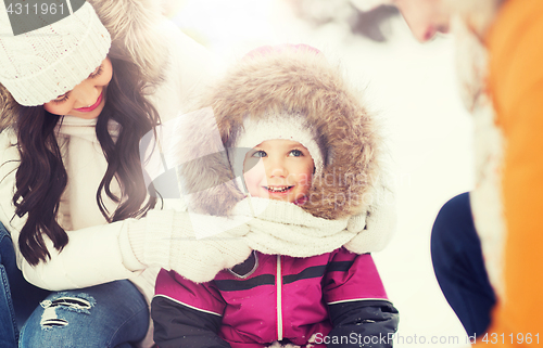 Image of happy family with child in winter clothes outdoors