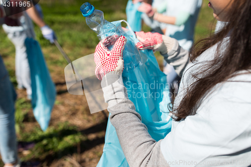 Image of volunteer with trash bag and bottle cleaning area