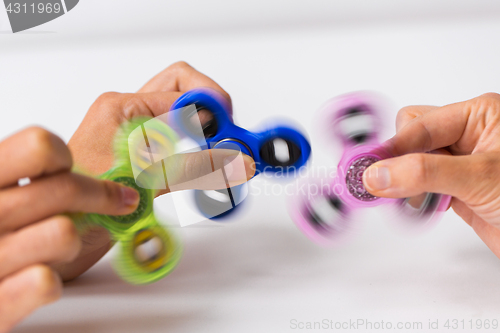 Image of close up of hands playing with fidget spinners