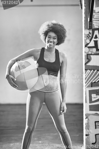 Image of black woman carrying crossfit ball