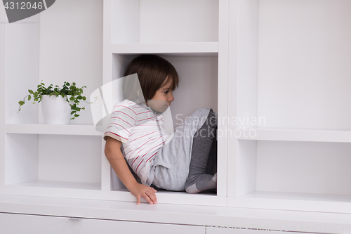 Image of young boy posing on a shelf